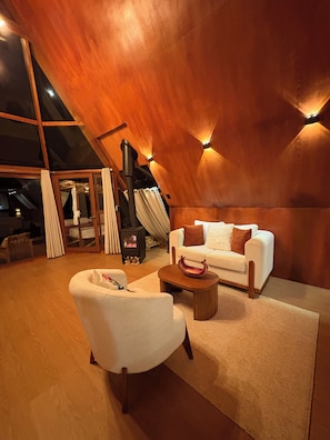 Un interior moderno con un sofá blanco, una mesa de centro de madera y una chimenea.