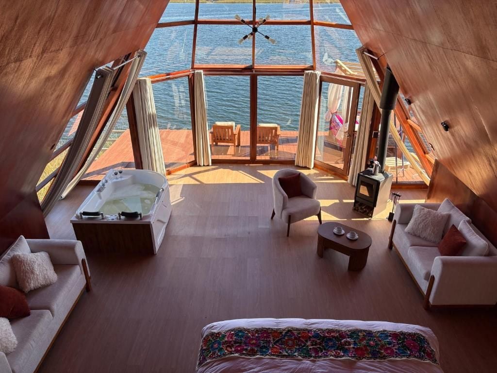 Une chambre dotée d’un grand lit, de deux fauteuils, d’une petite table et d’un jacuzzi.