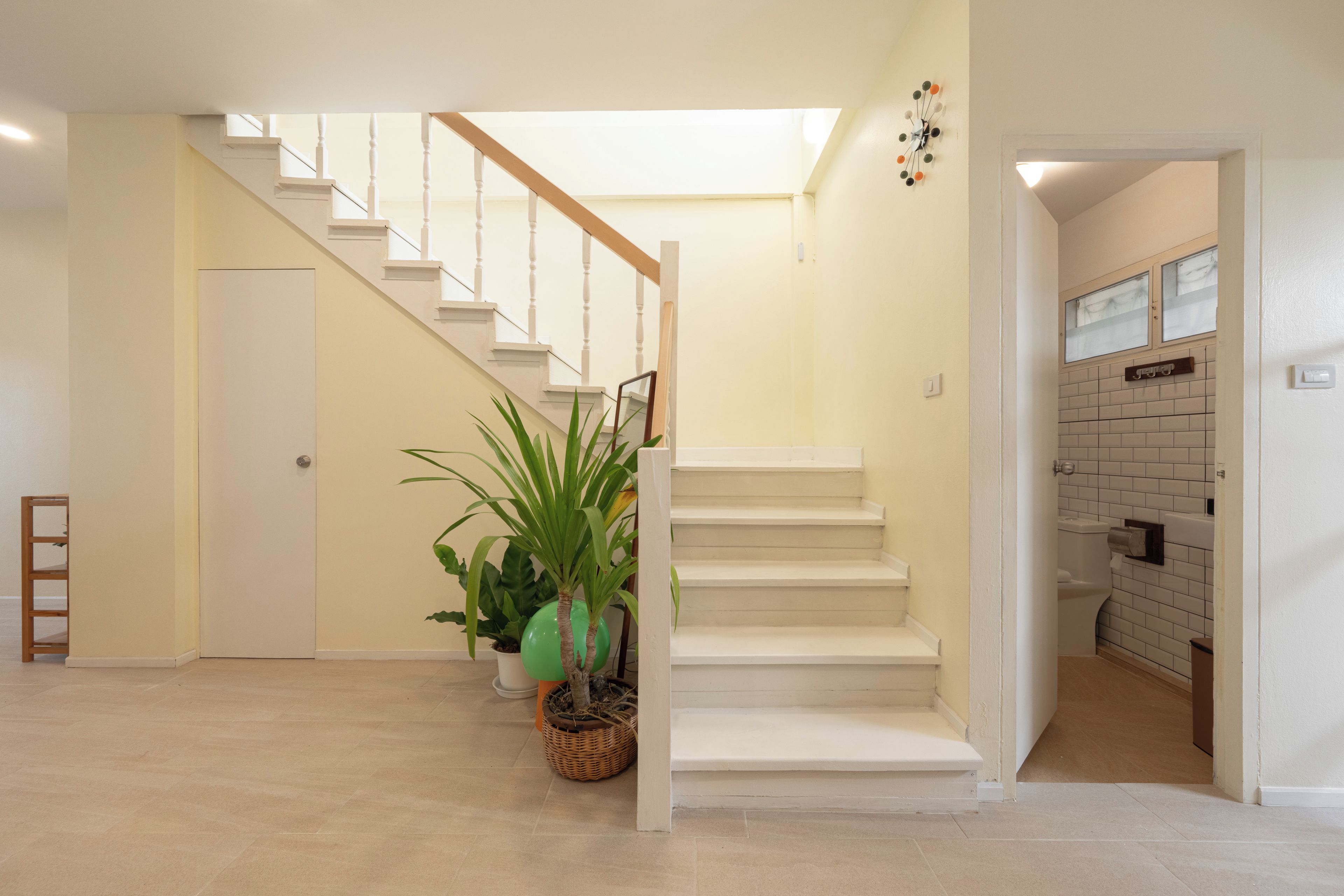 Un escalier avec des rampes blanches menant à un palier.