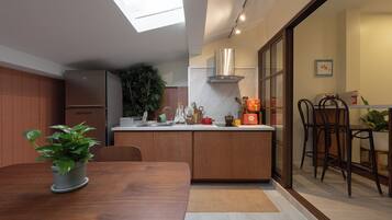 Eine moderne Küche mit einem Holztisch, einem eingebauten Backofen und einem großen Fenster über der Spüle.