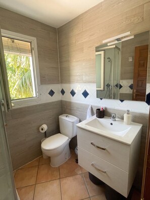A bathroom with a toilet, sink, mirror, and a window. - GuestReady - Coastal Apartment in Dénia (Denia)