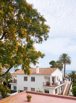 A two-story building with a balcony, a potted plant, and a view of the sea. - GuestReady - Coastal Apartment in Dénia (Denia)