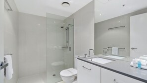 A modern bathroom with a glass-enclosed shower, a toilet, a sink, and a mirror. - Circle On Cavil Apartment 2205 (Surfers Paradise)