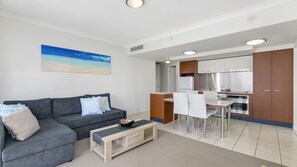 A modern apartment with a living area, kitchenette, and dining space. - Chevron Renaissance Apartment 1092 (Surfers Paradise)