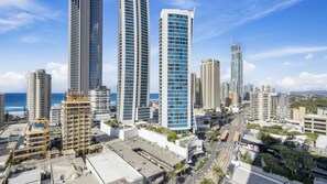 A cityscape with high-rise buildings, a clear sky, and a view of the ocean. - Chevron Renaissance Apartment 1135 (Surfers Paradise)