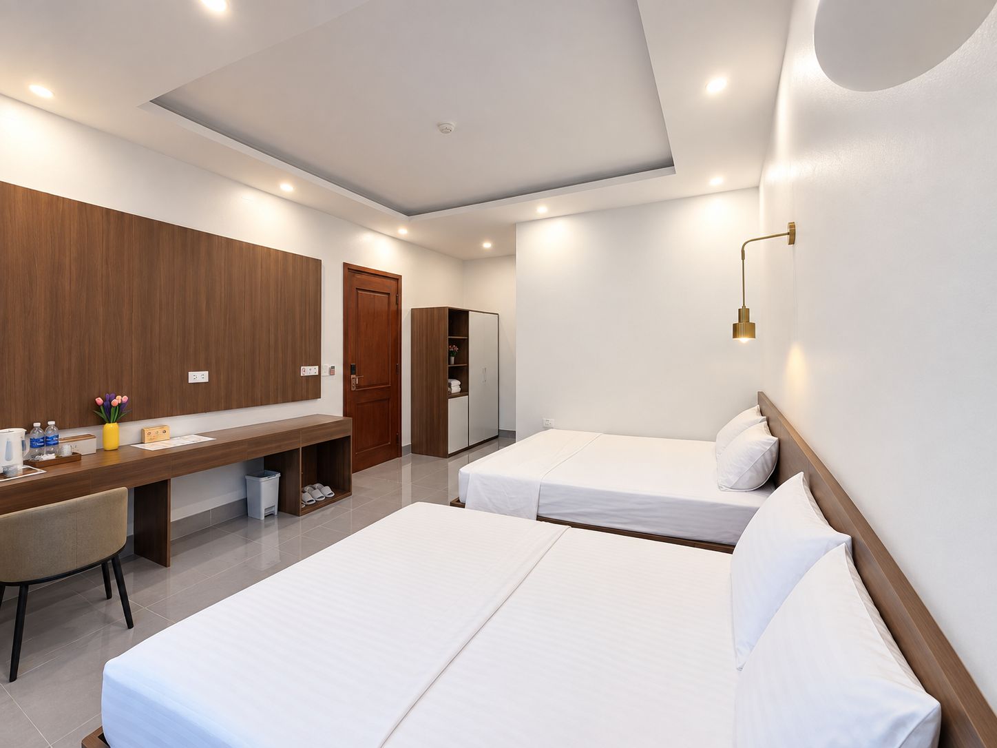 Une chambre d’hôtel avec deux lits, un bureau, une armoire et une salle de bain.