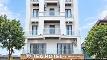 Ein mehrstöckiges Hotel mit moderner Fassade, das Balkone in jeder Etage und einen Eingangsbereich mit der Beschriftung 'TEAHOTEL by CHIEN HAO' im Erdgeschoss bietet.