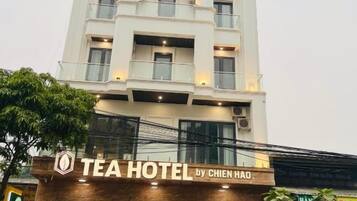 A multi-story building with a sign reading 'TEA HOTEL by CHIEN HAO'.