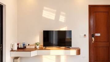 A modern room with a built-in TV, a wooden counter, and a door with a lock.