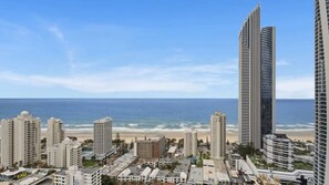 Een kuststreekgids met hoge gebouwen, een strand en een heldere lucht.