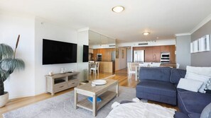 A modern living room with a flat-screen TV, a sofa, and a coffee table. - Chevron Renaissance Apartment 1333 (Surfers Paradise)