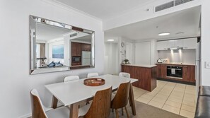 A modern kitchen with white cabinets, a built-in oven, and a refrigerator. - Chevron Renaissance Apartment 2146 (Surfers Paradise)
