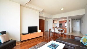 A modern living room with a flat-screen TV, a sofa, and a coffee table. - Chevron Renaissance Apartment 2364 (Surfers Paradise)