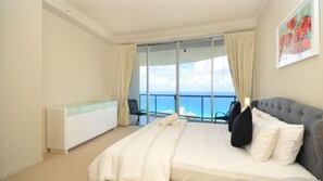 A hotel room with a bed, a bedside table, a chair, and a view of the sea. - Chevron Renaissance Apartment 2364 (Surfers Paradise)