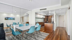 A modern interior with a dining area, kitchen, and a view of the outdoors. - Chevron Renaissance Apartment 2402 (Surfers Paradise)