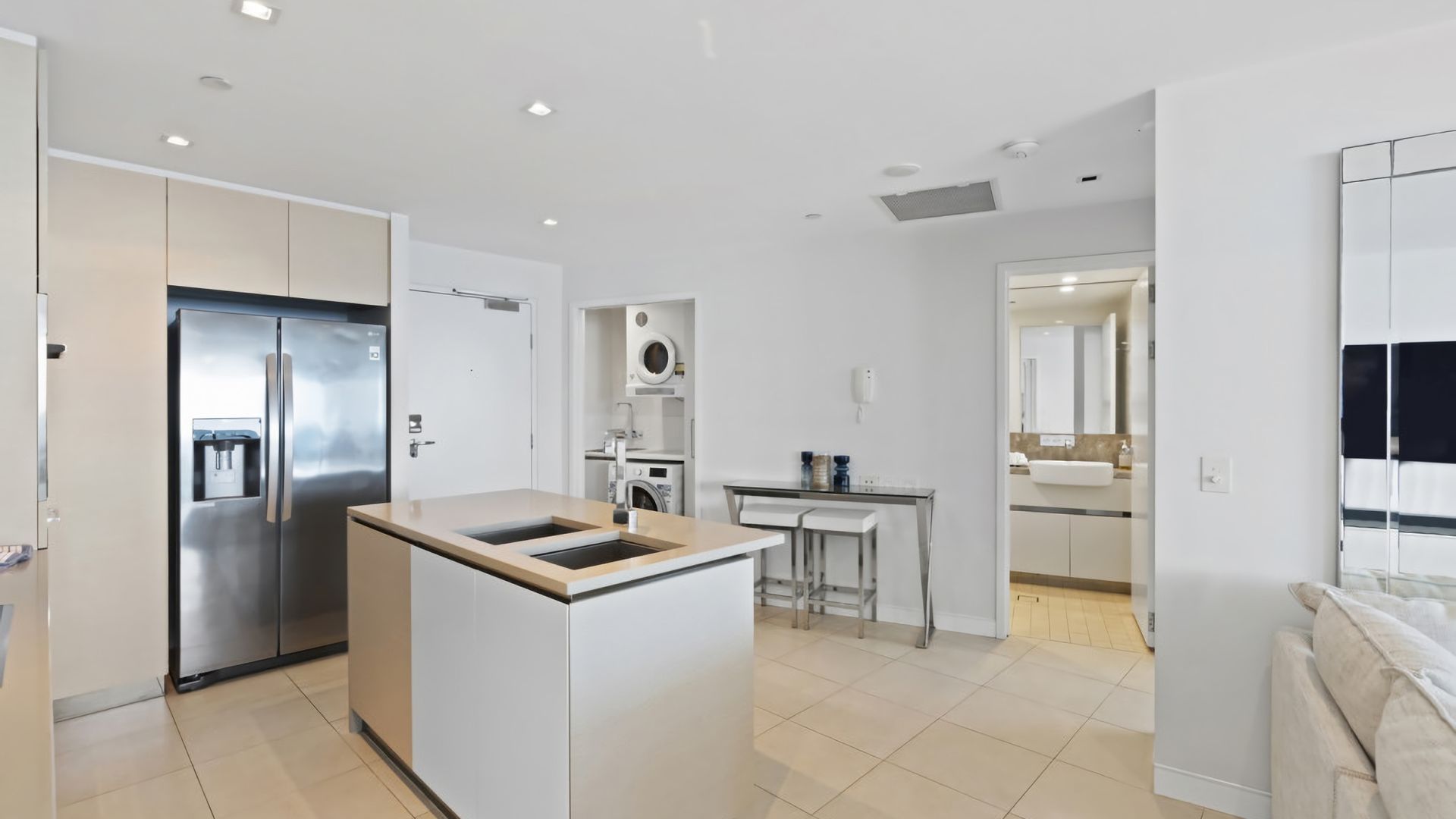 A modern kitchen with a built-in refrigerator, a sink, and a small island.