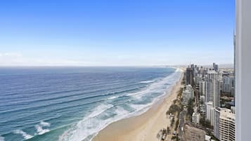 A coastal cityscape with a beach and high-rise buildings.