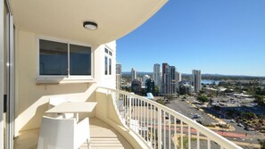 Ein Balkon mit Blick auf eine Stadtlandschaft und einen Parkplatz.