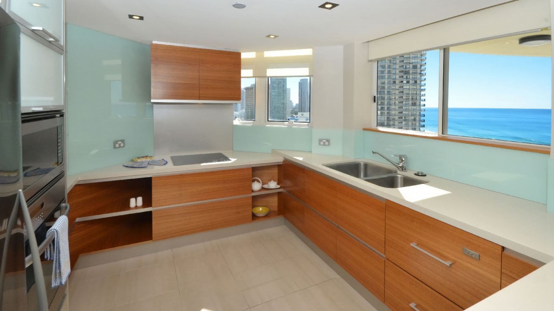 Eine moderne Küche mit Backofen, Spüle und Fenster mit Meerblick.