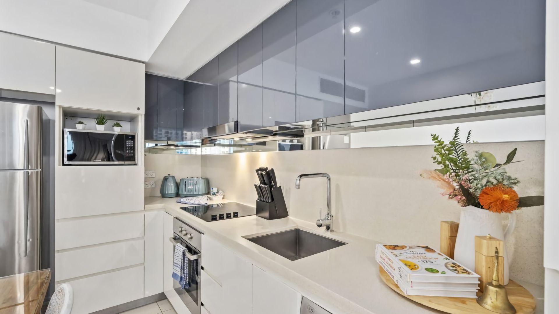 A modern kitchen with stainless steel appliances, a built-in microwave, and a large island with a sink.