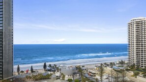 A coastal cityscape with high-rise buildings, a beach, and a clear sky. - Orchid Residences Apartment 11504 (Surfers Paradise)