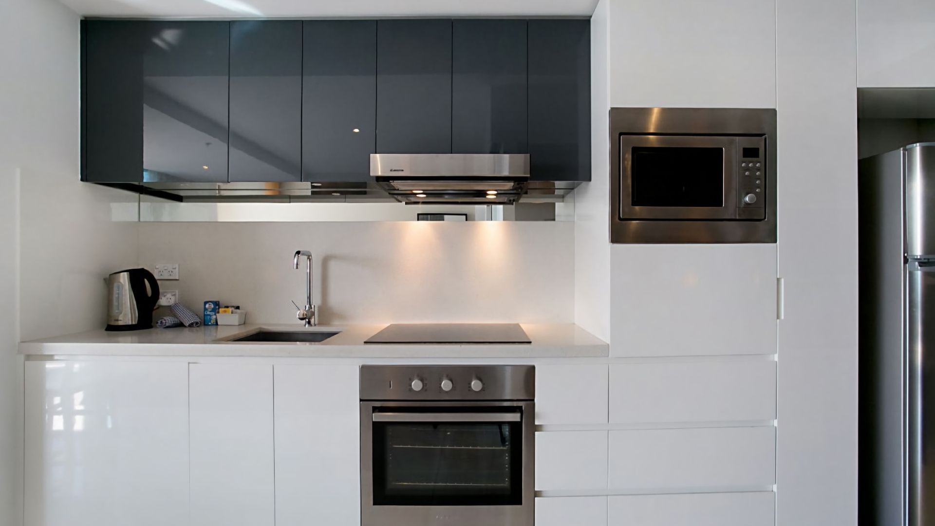 A modern kitchen with stainless steel appliances, including a microwave, oven, and coffee maker.