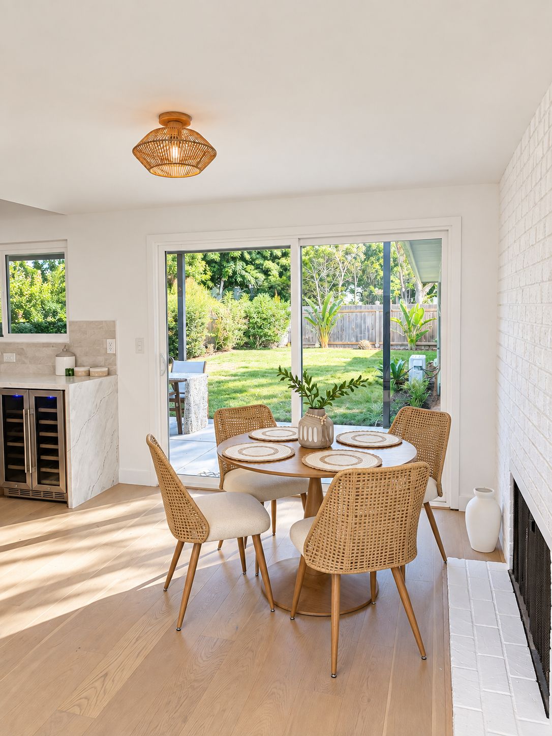 Una cocina moderna con comedor, ventanas amplias y vista al jardín trasero.
