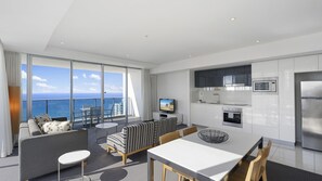 Ein modernes Wohnzimmer mit Balkon, Essbereich und Küche mit Edelstahlgeräten.
