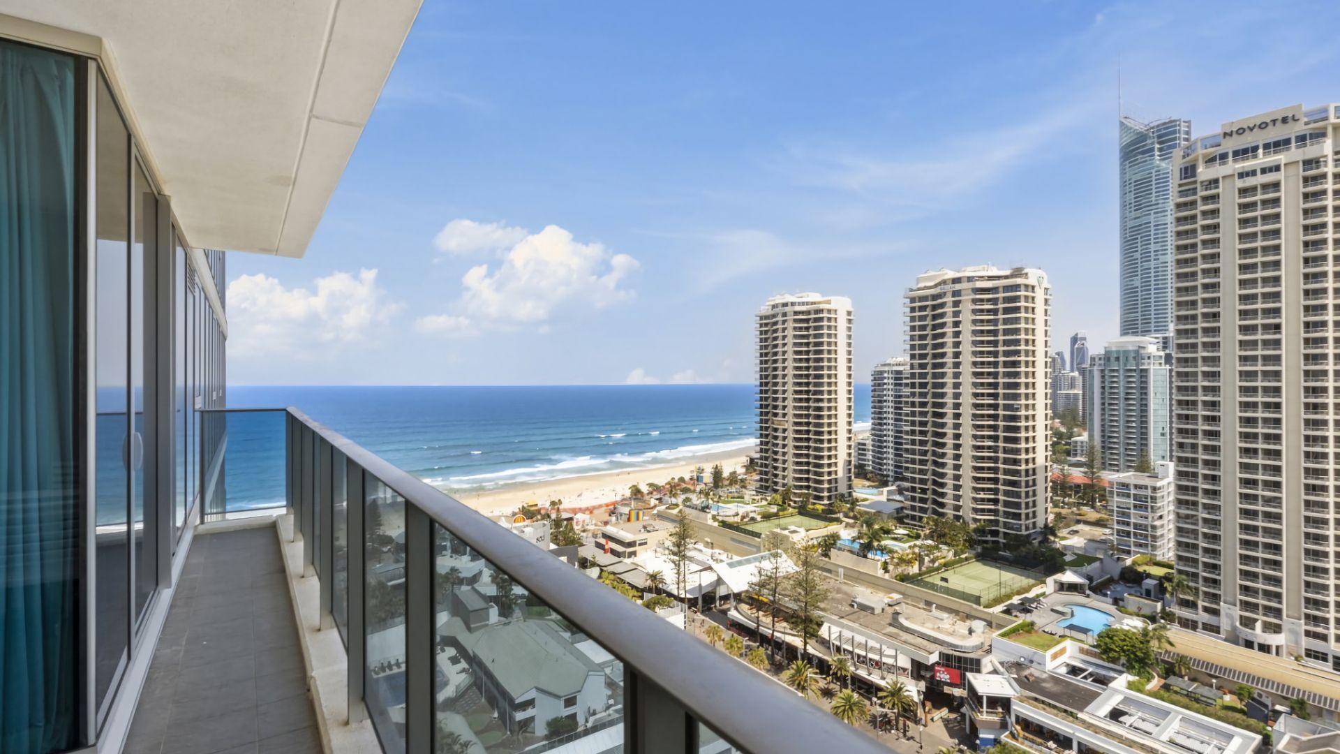 A high-rise hotel with a view of the beach and ocean.