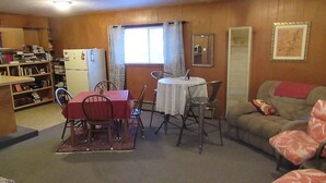 Un espacio habitable compacto con una mesa de comedor, sillas, un sofá y un refrigerador.