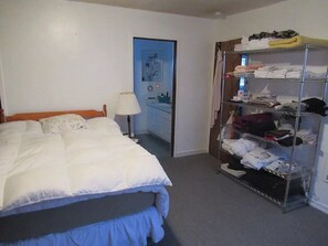 Una habitación de hotel con cama, armario y puerta que da a un baño.