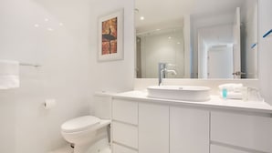 A modern bathroom with a toilet, a sink, and a mirror. - Orchid Residences Apartment 22303 (Surfers Paradise)