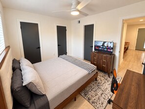 A bedroom with a bed, a television, a desk, and a chair. - Modern 2BR | Near Downtown Austin & SoCo (Austin)