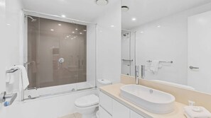 A modern bathroom with a glass-enclosed shower, a standalone toilet, and a freestanding bathtub. - Orchid Residences Apartment 22905 (Surfers Paradise)