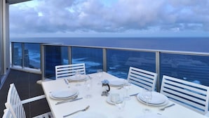 Mesa para cuatro personas dispuesta con vista al océano y al paisaje urbano.