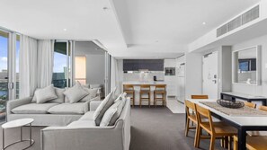 A modern apartment with a living room, dining area, and kitchen. - Orchid Residences Apartment 23405 (Surfers Paradise)