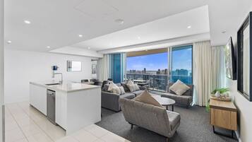 A modern apartment with a kitchen, living area, and large windows offering a city view.
