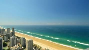A coastal cityscape with high-rise buildings and a beach.
