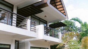 Un edificio de varios pisos con balcones y un espacio exterior cubierto.
