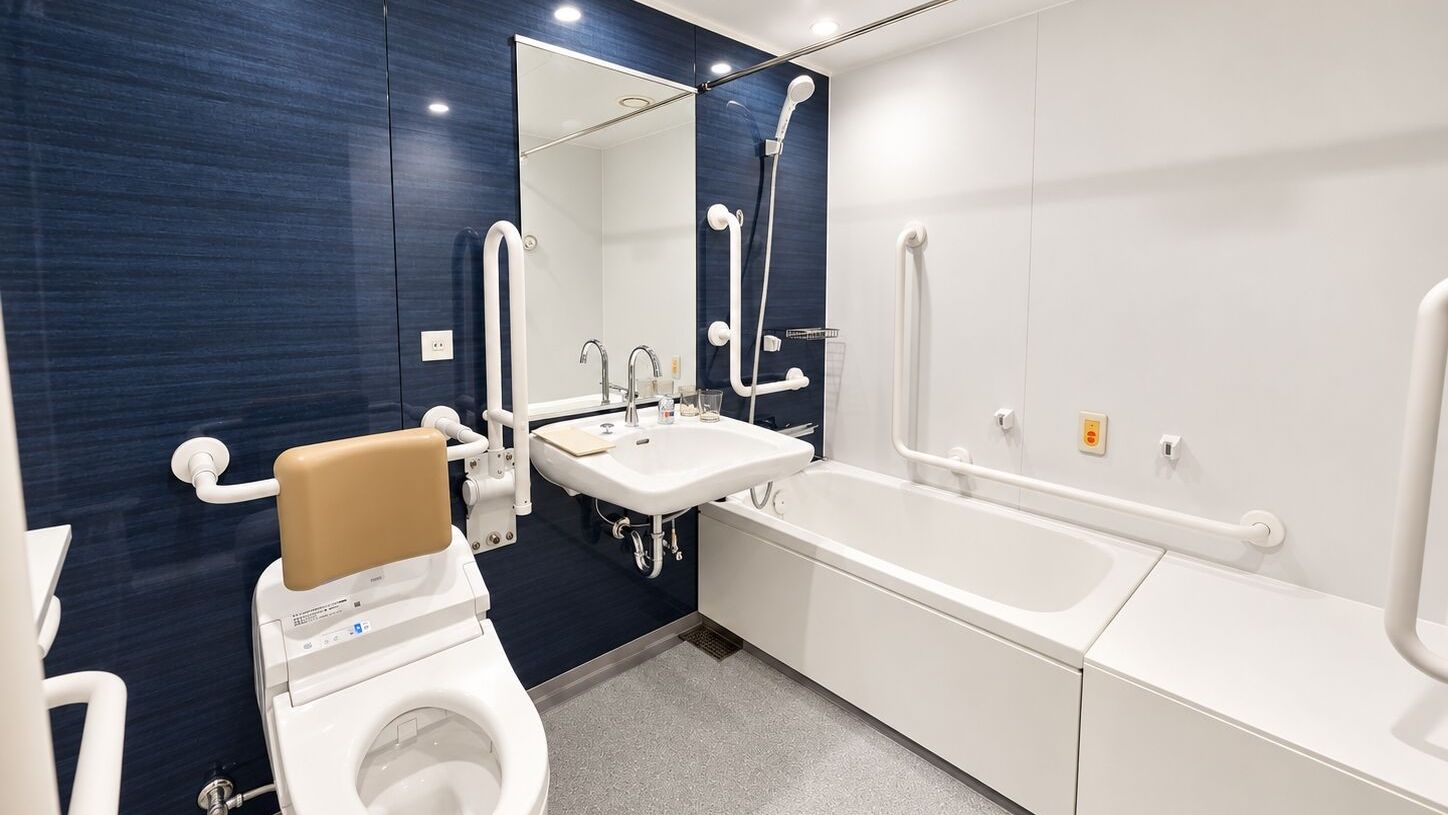 Een moderne badkamer met een wit toilet, een wastafel en een bad.