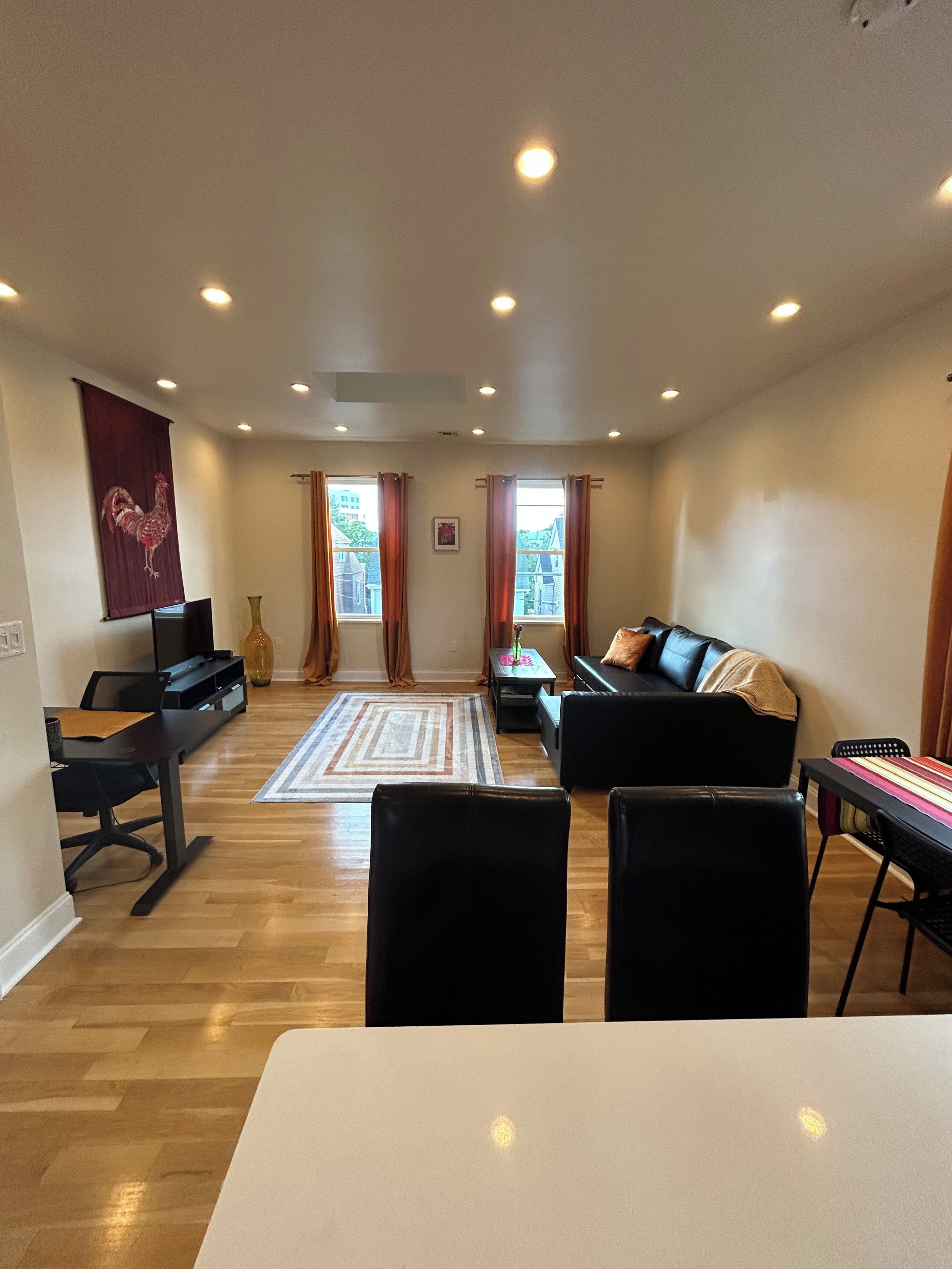 A living room with a sofa, a coffee table, a TV, and a dining table.