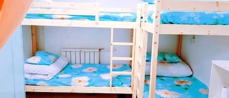 A bunk bed room with a ladder, a radiator, and a white dresser.