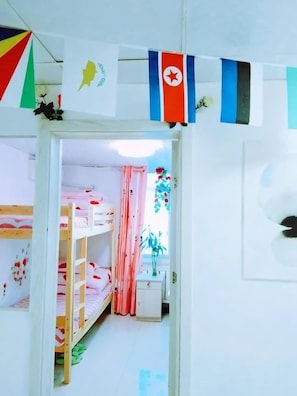 Lapsen makuuhuone, jossa on kerrossängyt, pieni työpöytä ja ikkuna, jossa on verhot.