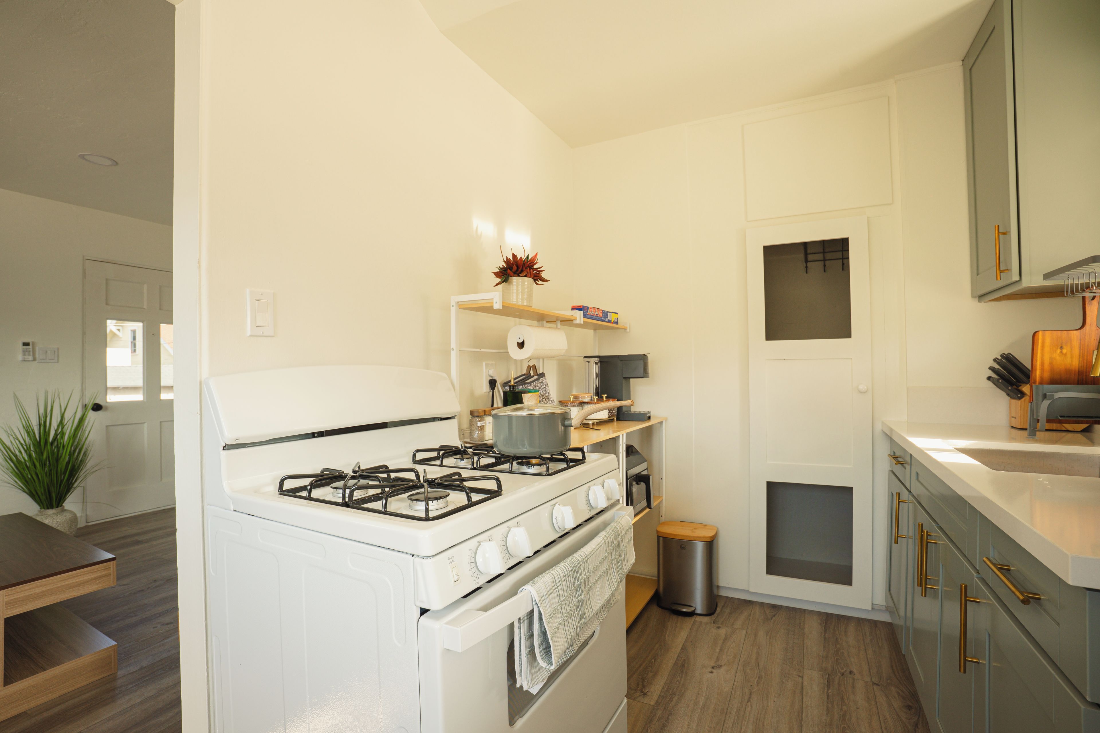 Una cocina compacta con estufa a gas, horno y una pequeña encimera con lavabo.
