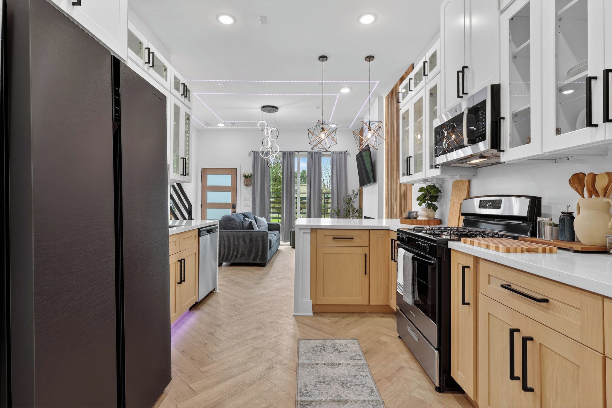 Una cocina moderna con una isla central, electrodomésticos integrados y un comedor con sofá.
