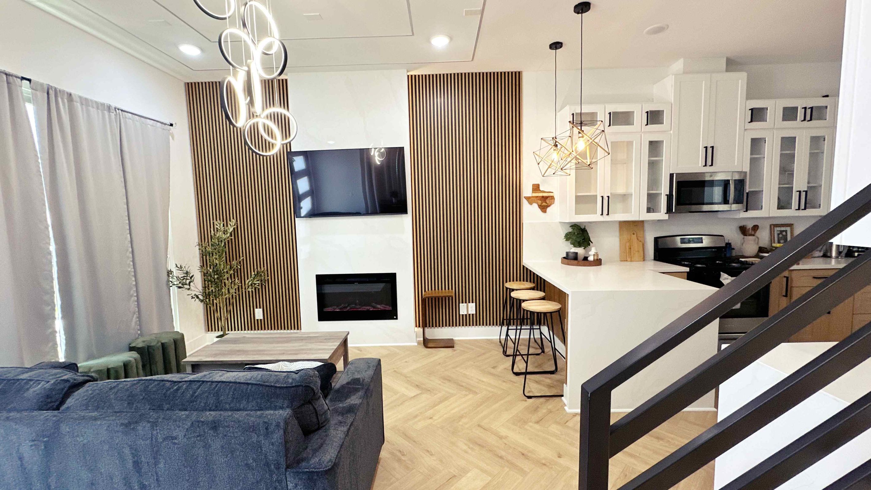 A modern living room with a sofa, a TV, and a fireplace.