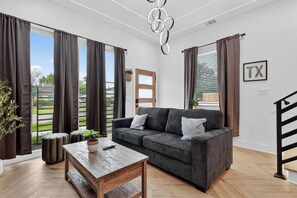 Ein Wohnzimmer mit einer Couch, einem Holztisch und einer Treppe.