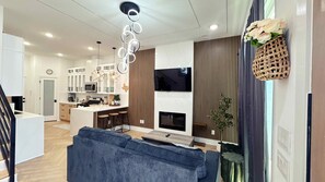 A modern kitchen with white cabinets, a central island, and a dining area with a blue sofa. - Luxury 3br Near Texas Medical*NRG Stadium*Garage (Houston)