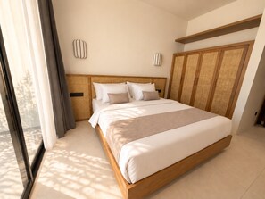 A modern bedroom with a large bed, wooden headboard, and a wardrobe with a woven back panel. - Villa Aurora By Aura (Badung)