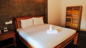 Quarto de hotel com cama grande, cabeceira de madeira, mesas de cabeceira e guarda-roupa.